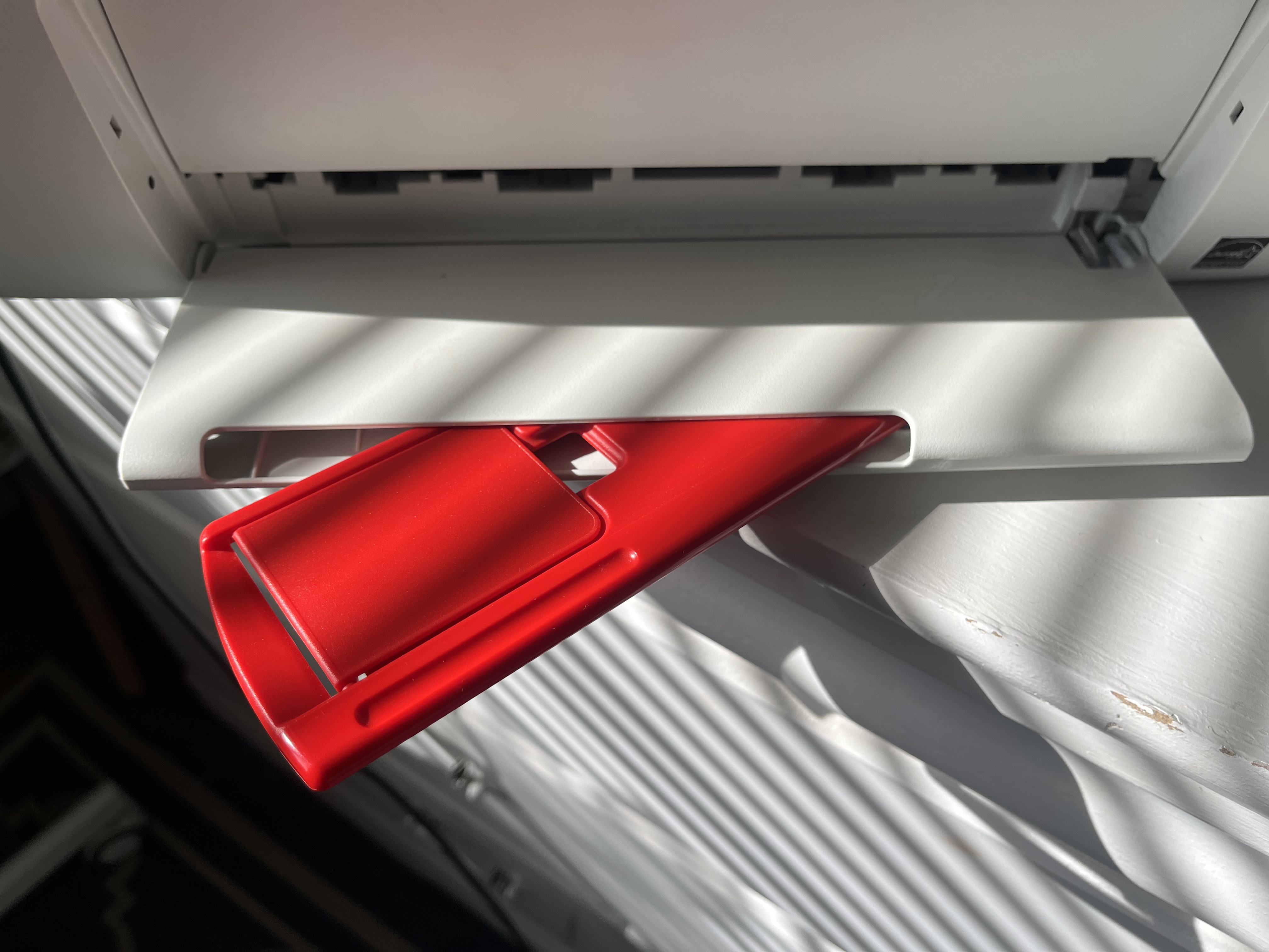 This is the sound of the printer’s output tray being adjusted, creating a light plastic click followed by a soft sliding noise as it moves into place.